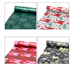 Detailed view of four festive gift wrapping paper rolls with snowflakes and bows patterns