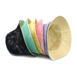 Tie-dye reversible bucket hats in multiple colors stacked on a white background