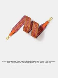 Close-up of 5cm wide woven orange geometric pattern strap with leather and gold metal clips