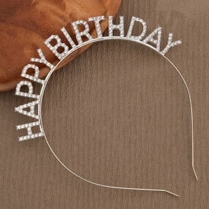 Close-up of sparkling silver rhinestone HAPPY BIRTHDAY headband on a rustic background
