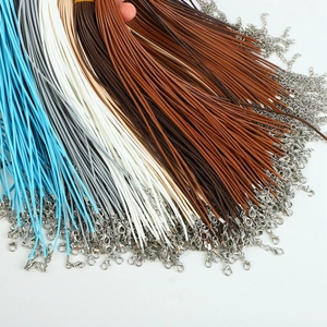 Close-up of assorted colorful wax cords for necklaces with silver lobster clasps and chains