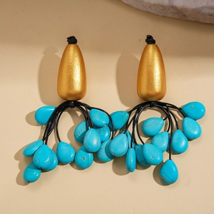 Detail view of Bohemian tassel earrings with gold teardrop studs and turquoise stones