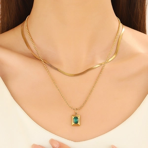 Double-layered gold titanium necklace with a flat snake chain and green gemstone pendant