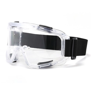Close-up of industrial safety goggles with transparent PVC frame and adjustable black strap
