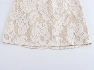 Detailed close-up of beige skirt hem featuring intricate white floral lace and smooth lining