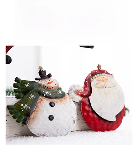 Detail of vintage metal Christmas ornaments featuring a snowman and Santa Claus design