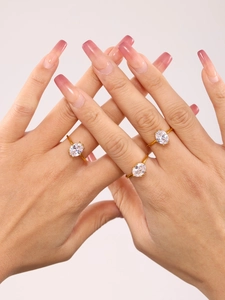 Macro view of three gold rings with oval clear zircon stones on a model's hand