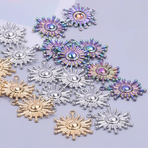 Macro shot of sun-shaped stainless steel charms in gold, silver and rainbow plating