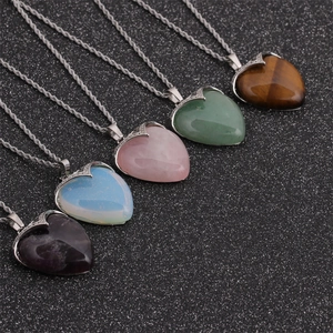 Set of five heart-shaped crystal pendant necklaces in various colors on black background