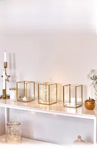 Detail of geometric gold glass candle holder with LED string lights for home decor