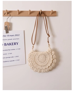 Detail of the intricate lace crochet pattern and leather strap on this woven bag