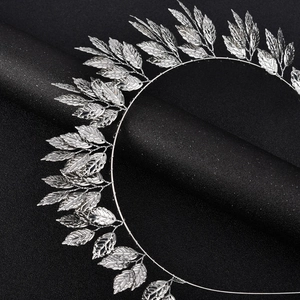 Detailed macro view of a silver leaf hairband with intricate metallic textures and shine