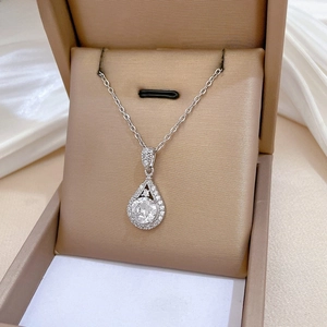 Close-up of a teardrop-shaped zircon pendant on a silver-plated chain with micro-pave setting