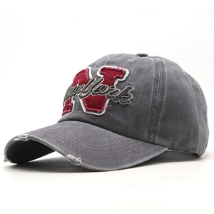 Close-up of vintage grey cotton baseball cap with New York embroidery and distressed brim