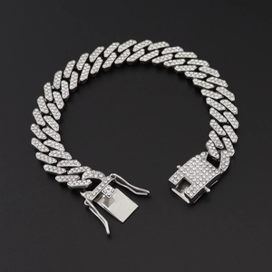 Macro shot of silver paved Cuban link bracelet with secure buckle on black background
