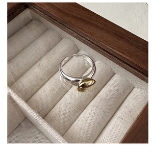 Detail of S925 sterling silver open ring with gold oval inlay inside a luxury jewelry box