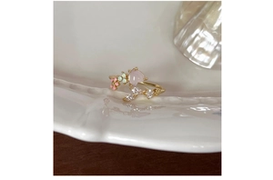 Detail view of heart-shaped pink quartz ring with flower accents and crystal inlays
