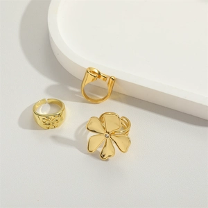 Three gold flower rings including a clover with diamond and butterfly open band set