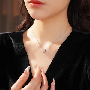 Detailed close-up of double-loop pavé zircon pendant on a silver-plated O-chain necklace