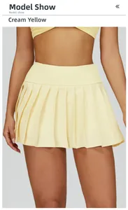 Detail of high-waisted pleated tennis skirt in butter yellow featuring breathable fabric