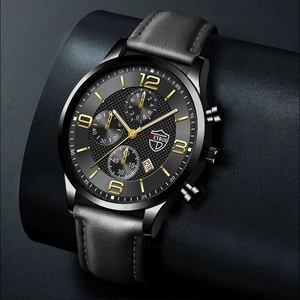 Détail d'une montre à quartz avec cadran noir, index dorés et bracelet en cuir