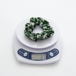 Detail shot of Christmas plaid scrunchie weighing 3.7g on a white digital scale