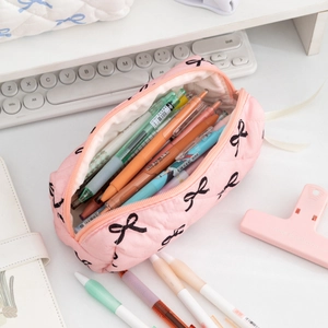 Pink quilted pencil case with bow patterns showing large capacity storage for pens