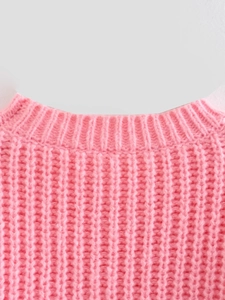 Dettaglio di un maglione rosa acceso con scollo rotondo a costine e trama in maglia spessa