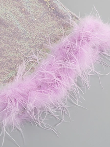 Detail of purple sequin fabric and luxury ostrich feather trim on a sexy bodycon dress