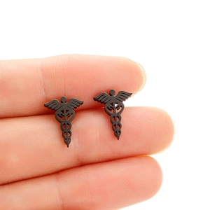 Macro shot of black stainless steel stud earrings featuring the medical Caduceus symbol