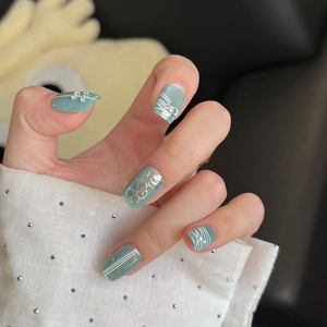 Short mint green square nails with silver butterflies and pearls on hands