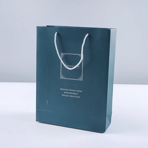 Deep green paper gift bag with white cotton rope handles and silver prestige logo print