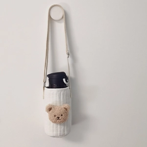 Detail of cream quilted cotton cup sleeve with cute 3D bear and adjustable shoulder strap
