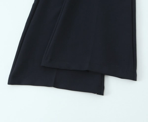 Detail of black crepe flared pants featuring a smooth finish and elegant wide-leg silhouette