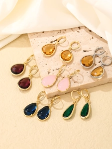Macro shot of assorted gemstone drop earrings with gold and silver crystal settings