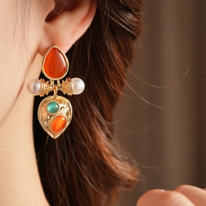 Detail of vintage earring with cat eye stone and pearls on a model's ear