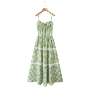 Detail of green plaid maxi dress featuring white lace trimmings and smocked waist design