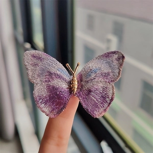 Detail of vintage embroidered butterfly brooch with purple and blue gradient wings