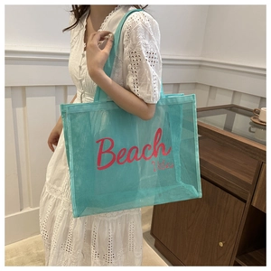 Detailed view of Tiffany blue mesh beach tote with pink Beach Vibes typography