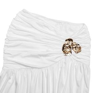 Detail of white one-shoulder dress featuring pleated fabric and golden flower buckle