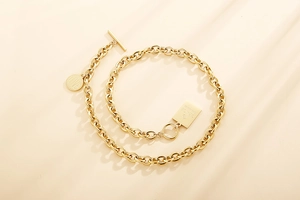 Dettaglio della collana a catena dorata con ciondoli quadrati LOVE e GRACE