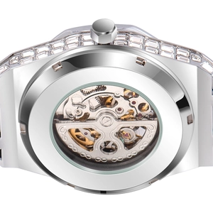 Macro view of mechanical watch movement through transparent back with silver diamond bezel