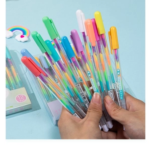 Close-up showing a hand holding 12 colorful rainbow gradient glitter pens in clear barrels