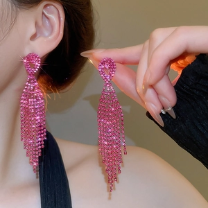 Detail of long rose red rhinestone tassel earrings with shimmering crystals on model