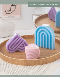 Artistic display of blue arch and purple heart scented candles on a round wooden tray
