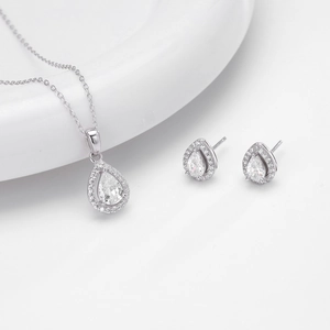 Elegant silver necklace and earrings set with pear-shaped cubic zirconia on white ceramic