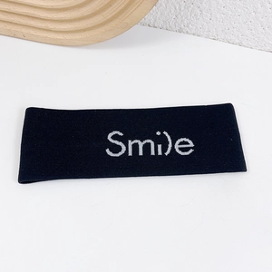 Slim black knitted sports headband featuring a white smile graphic on a plain background