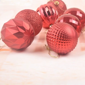 Macro detail of assorted red Christmas ornaments with diverse textures and golden strings