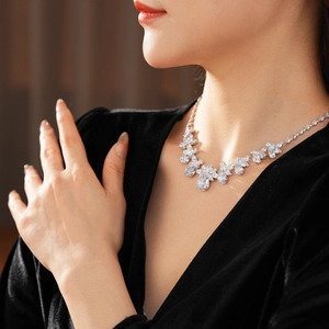 Close-up of elegant silver necklace with zircon floral pattern worn by a model