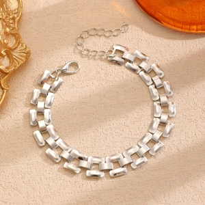 Polished silver punk link chain bracelet with lobster clasp and extension on a desk